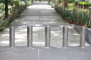 Steel barrier on the sidewalk in the park.